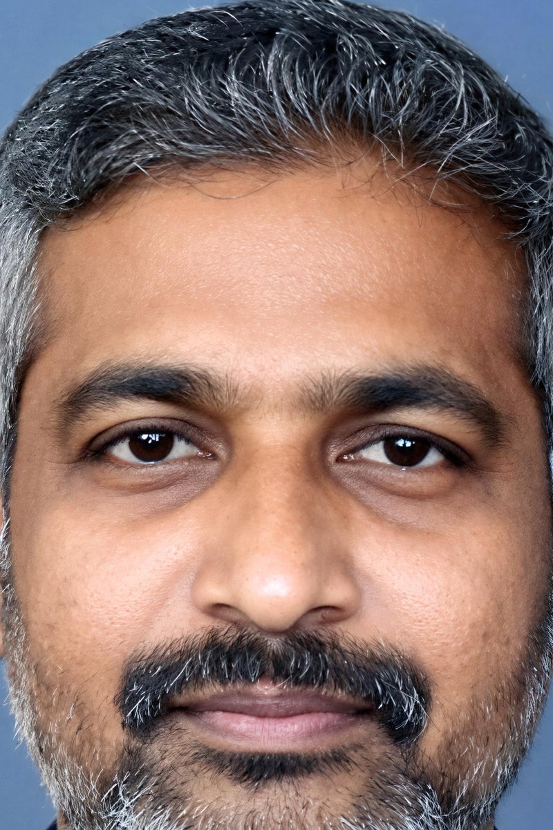 A close headshot shows a man with salt-and-pepper hair and a beard.